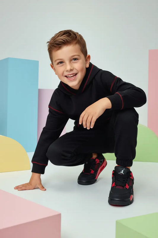 Mannequin enfant garçon portant l'Air Jordan 4 noire rouge