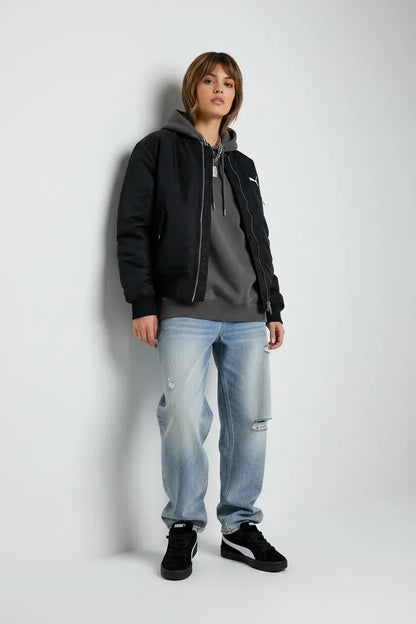 Mannequin femme debout contre mur avec Puma noires